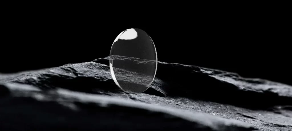 Verre ophtalmique Volcane posé sur une roche sombre, illustrant la précision et l'inspiration minérale de la marque.
