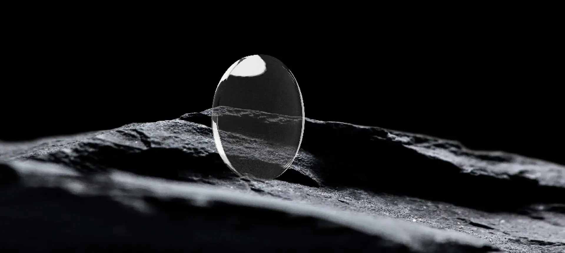 Verre ophtalmique Volcane posé sur une roche sombre, illustrant la précision et l'inspiration minérale de la marque.